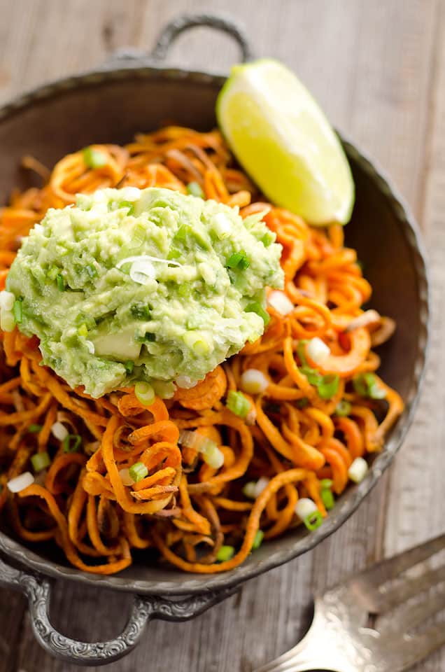 Spicy Roasted Sweet Potato Spirals with Guacamole is an amazingly delicious meatless dinner or appetizer with crispy sweet potatoes coated in garlic & chili powder and topped with a zesty guacamole.