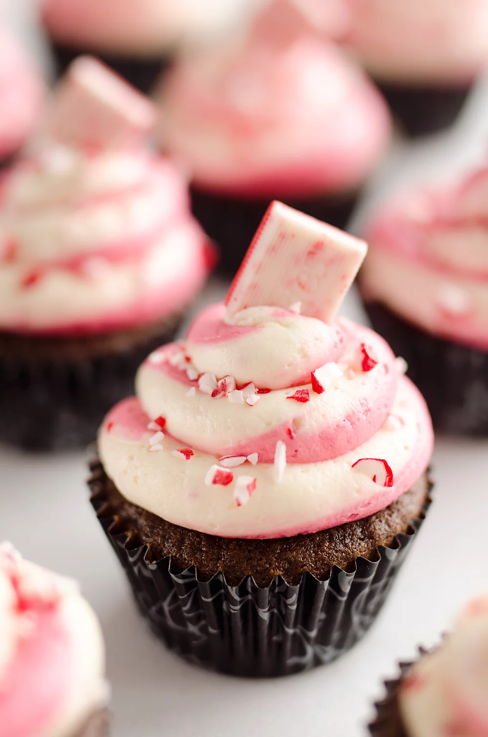 Peppermint Chocolate Candy Cane Cupcakes are a beautifully festive dessert perfect for the holidays! Moist homemade chocolate cupcakes are topped with a candy cane swirl of buttercream and topped with peppermint for a seasonal treat.