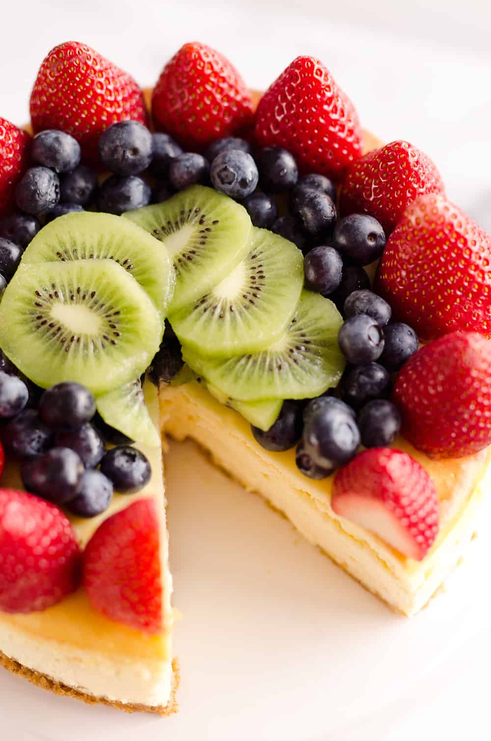 Creamy New York Cheesecake with Fresh Fruit is a rich and decadent dessert recipe that is sure to impress all your dinner guests!