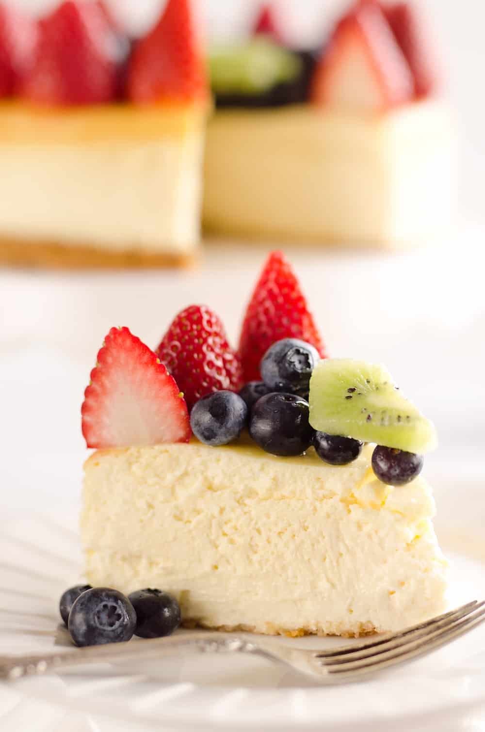 Creamy New York Cheesecake with Fresh Fruit is a rich and decadent dessert recipe that is sure to impress all your dinner guests!