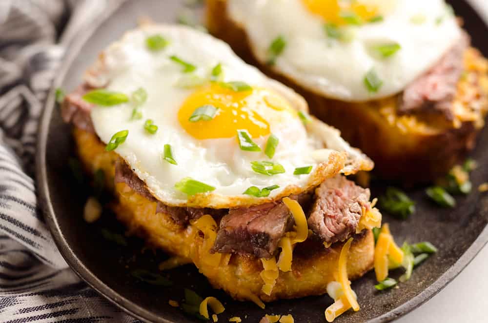 Breakfast Steak & Cheddar Toasts are a rich and decadent recipe filled with all the best parts of brunch. Tender steak is layered on top of a cheesy toast and topped with a sunny side up egg and scallions.