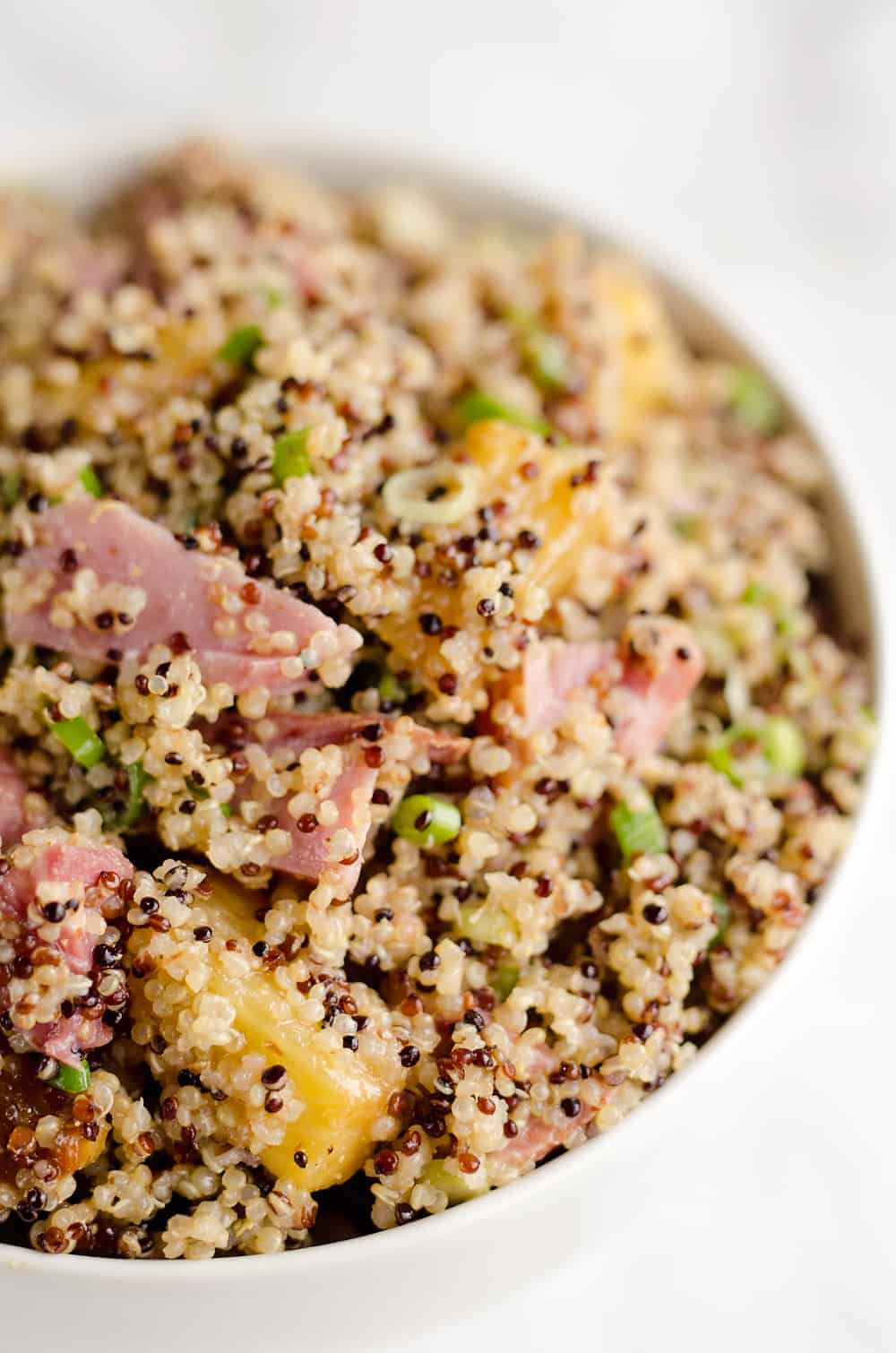 Roasted Pineapple & Ham Quinoa Salad is an easy recipe using up leftover ham with the perfect combination of sweet, salty and smokey flavors. Crunchy quinoa and oven roasted pineapple and ham are tossed with a Light Honey Dijon Vinaigrette for an easy 5 ingredient salad.