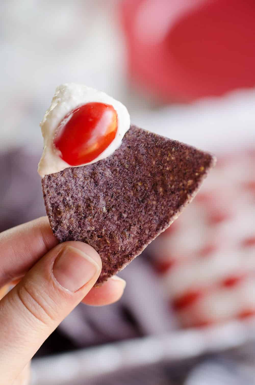 Patriotic Flag Parmesan Garlic Chip Dip is a festive appetizer recipe perfect for a holiday party with red, white and blue colors! A creamy Parmesan garlic dip is topped with cherry tomatoes and served with blue corn tortilla chips for a delicious dish sure to be a crowd pleaser.