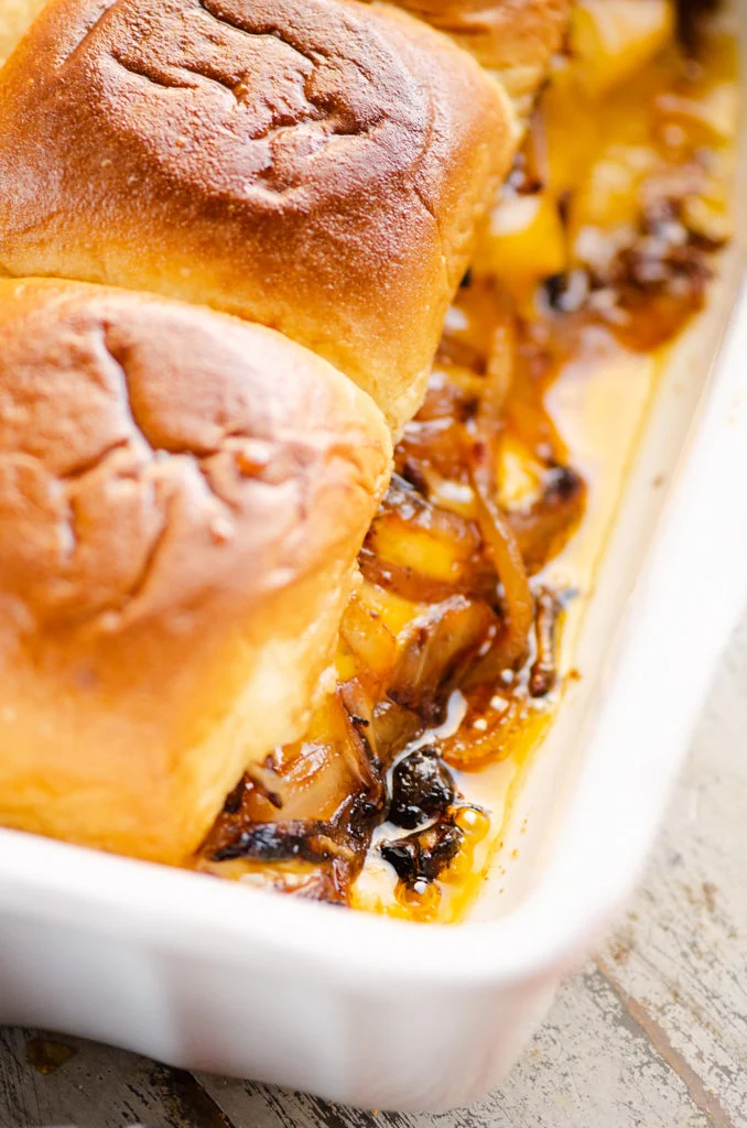 Cheesy Turkey Sliders with cheese oozing out into pan