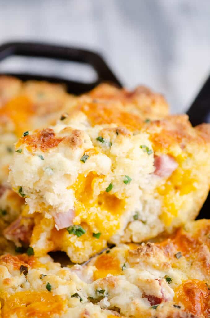 slice of ham and cheese butter swim biscuit with pockets of cheddar cheese on the inside